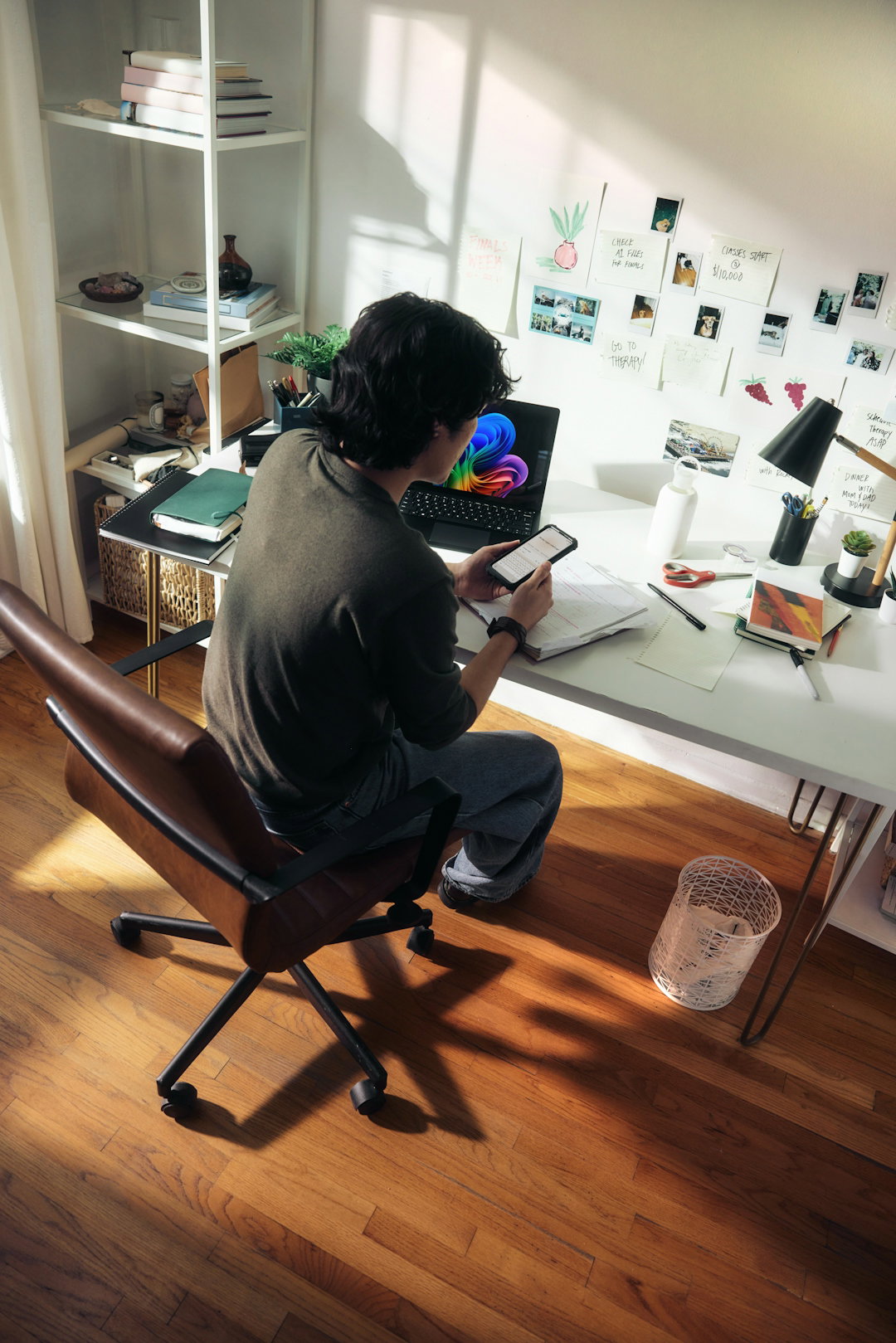 man-working-at-desk-with-laptop-and-phone-.jpg Man working at desk with laptop and phone.